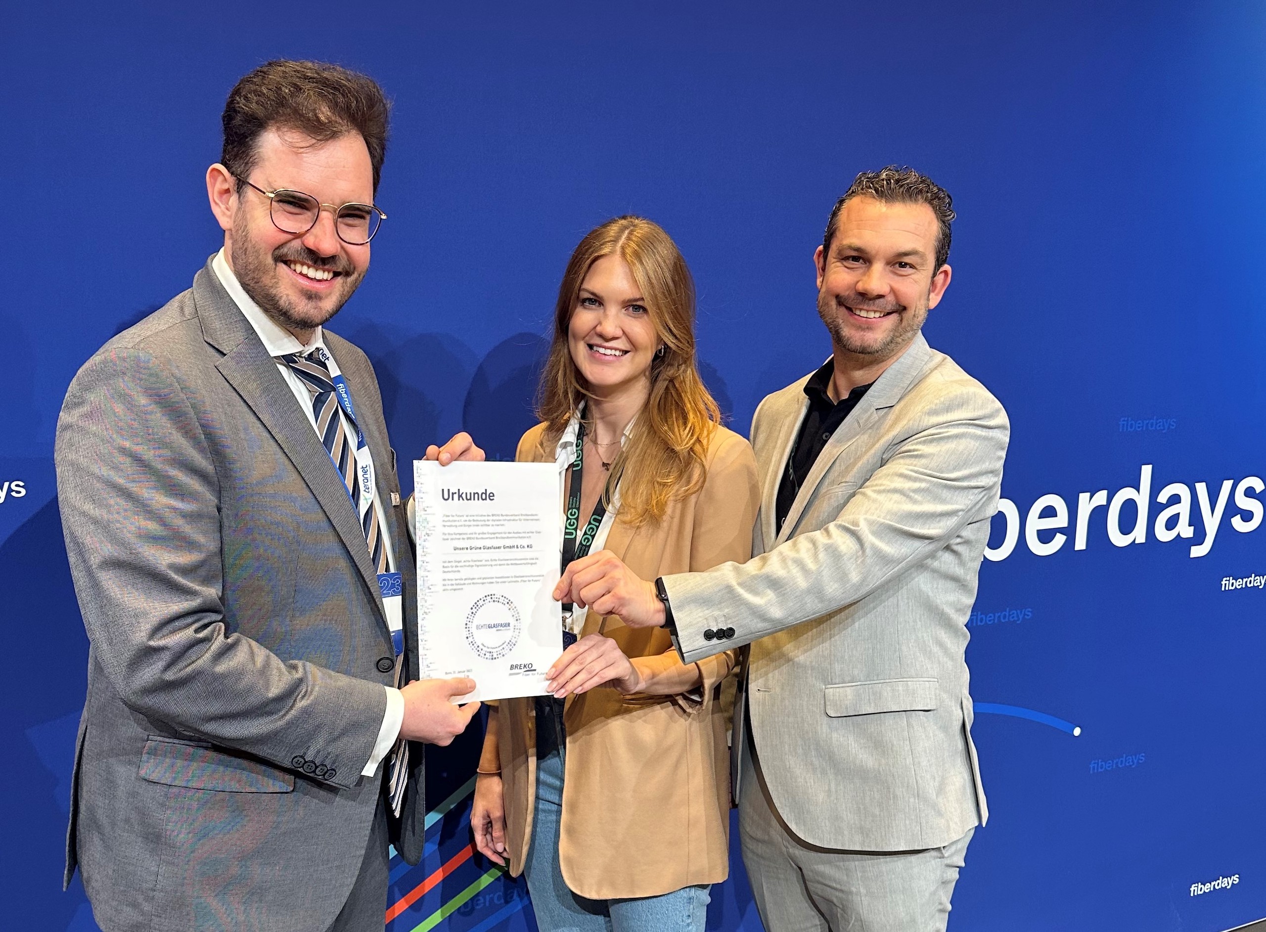 Zertifikatsübergabe bei den FiberDays 2023 durch das Team von Unsere Grüne Glasfaser für herausragende Leistungen.