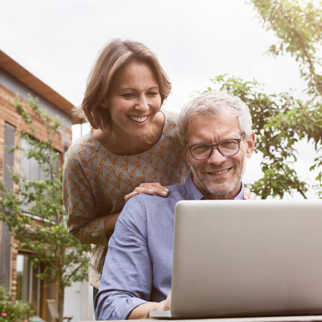 Glückliches Paar nutzt schnelle Internetverbindung von Unsere Grüne Glasfaser für digitale Aktivitäten im Freien.