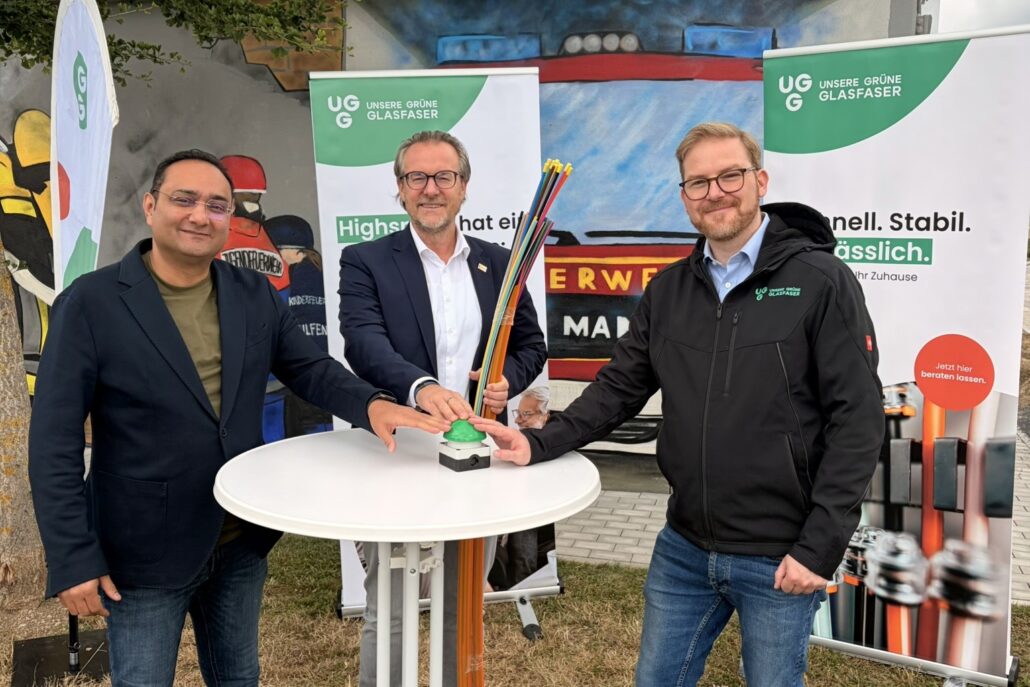 Vertreter von Unsere Grüne Glasfaser präsentieren innovative Glasfasertechnik für schnelles Internet.